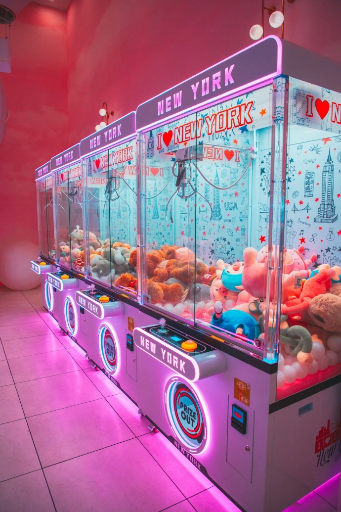 Row of colorful claw machines filled with plush toys.